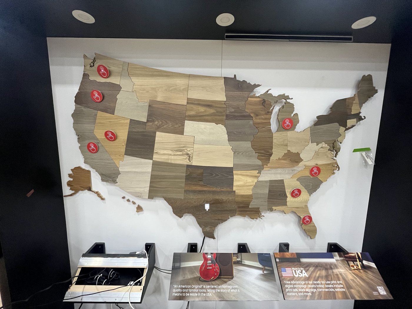 Wooden US state map wall with red touch buttons over a kiosk counter